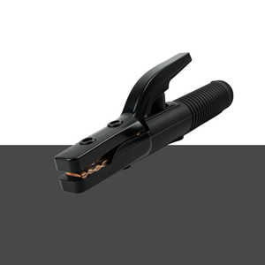 A black welding ground clip with a textured handle and copper-colored contact tips, shown against a split white and dark gray background.